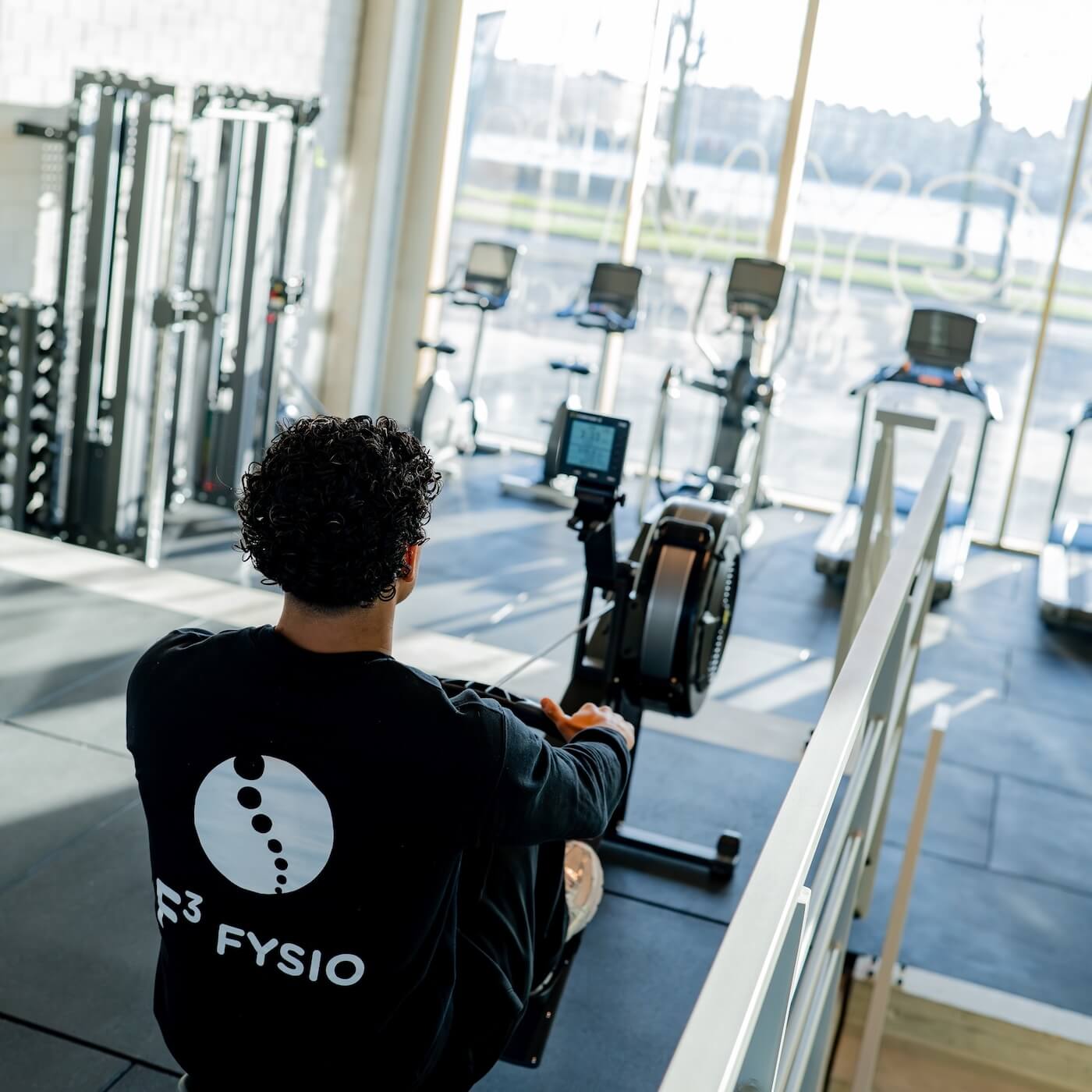 Lid traint op de roeimachine in F3 GYM aan de Hertekade
